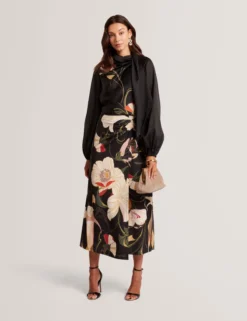 Bluse mit nouveau-wirbelartigem Bindekragen und langen Ärmeln