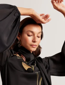 Bluse mit nouveau-wirbelartigem Bindekragen und langen Ärmeln